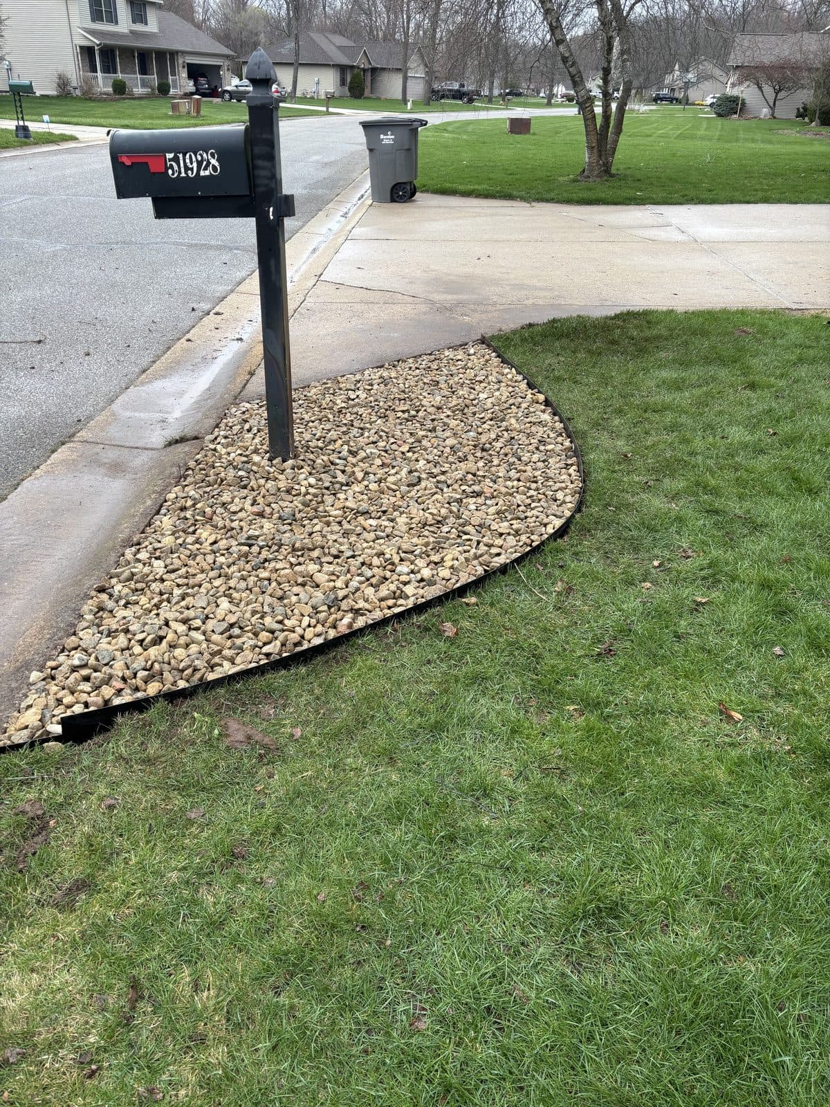 A fresh river-rock bed around a mailbox with a crisp lawn edge, by Fresh Cut Lawns.